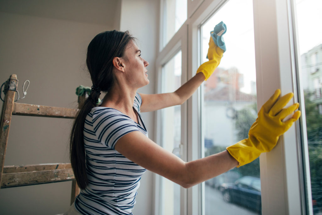 Mulher limpando janela. Imagem ilustrativa para texto como limpar janela de vidro.