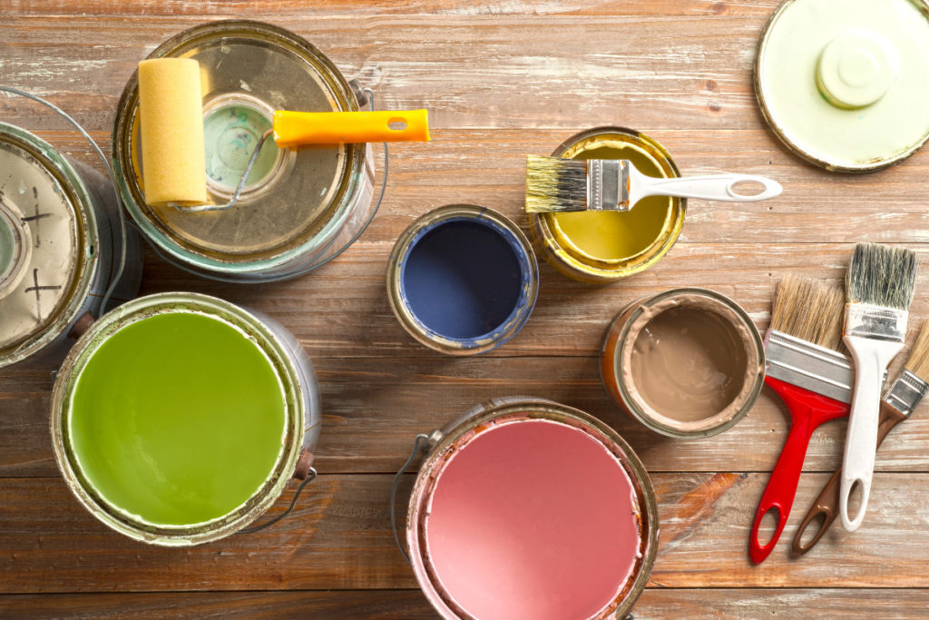 Latas de tintas coloridas para pintura da casa. Imagem ilustrativa para texto O que é cromoterapia.