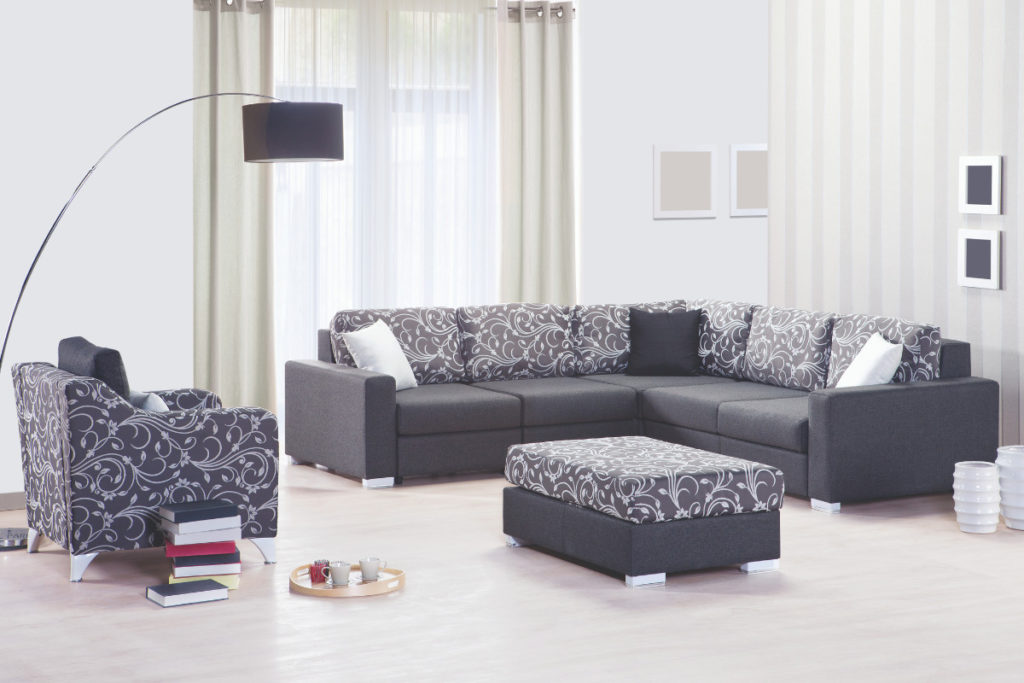 Um sofá grande e escuro em uma sala ampla. Imagem ilustrativa para texto tipos de sofá.