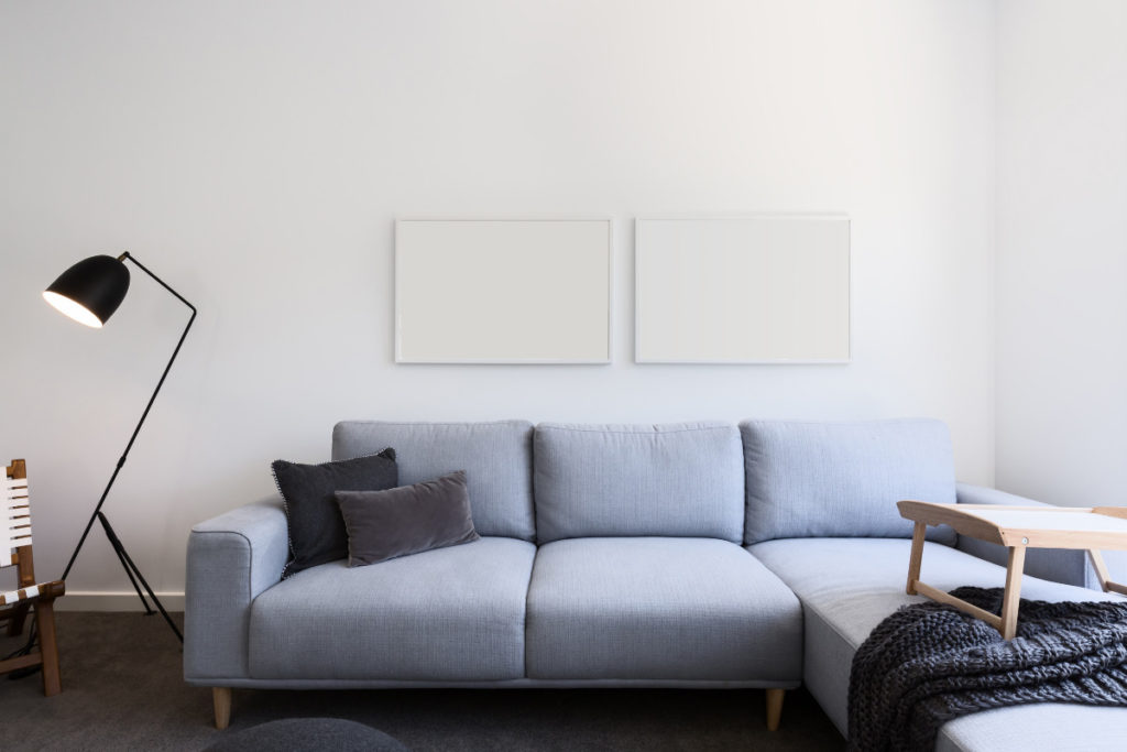 Sofá azul em cômodo com luminária do lado. Imagem ilustrativa para texto tecido para sofá.