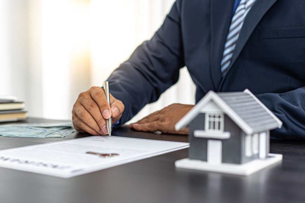 homem contratando um seguro residencial conferindo documentos.