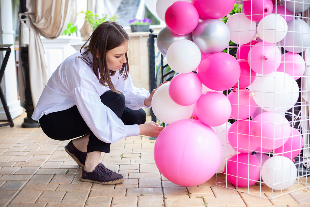 Mulher colocando balões em sua decoração de aniversário
