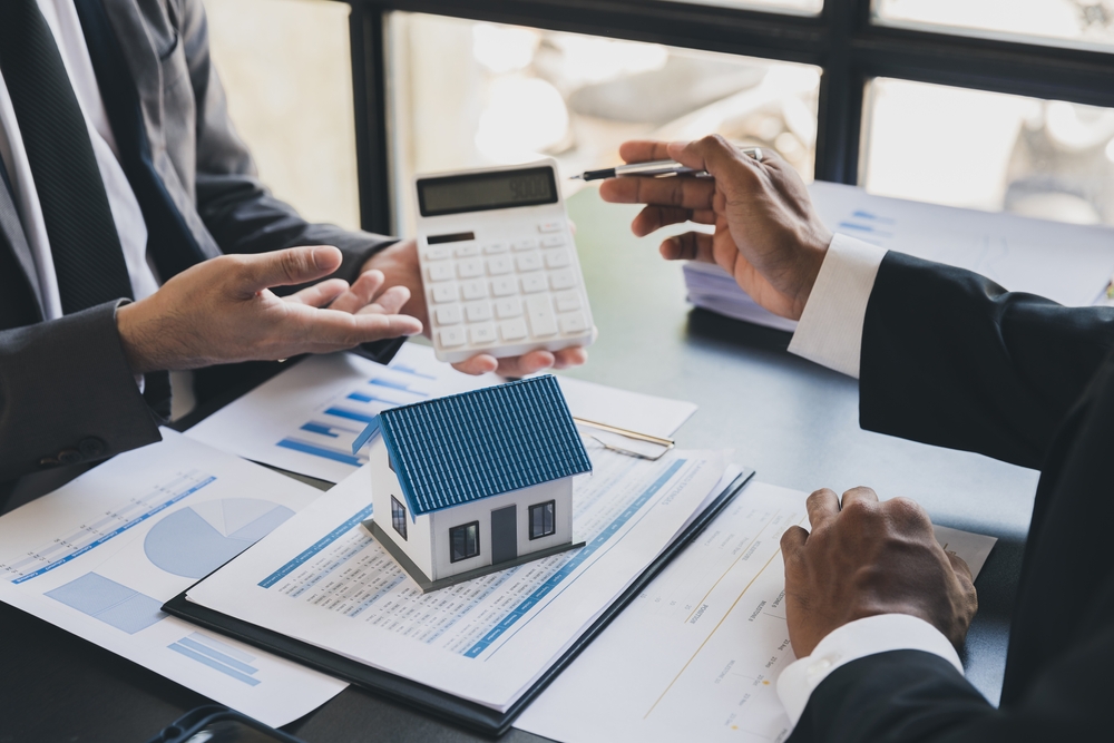 Interveniente quitante: descubra se é vantajoso para você Imagem de calculadora em uma mesa para negociação de valores de contrato